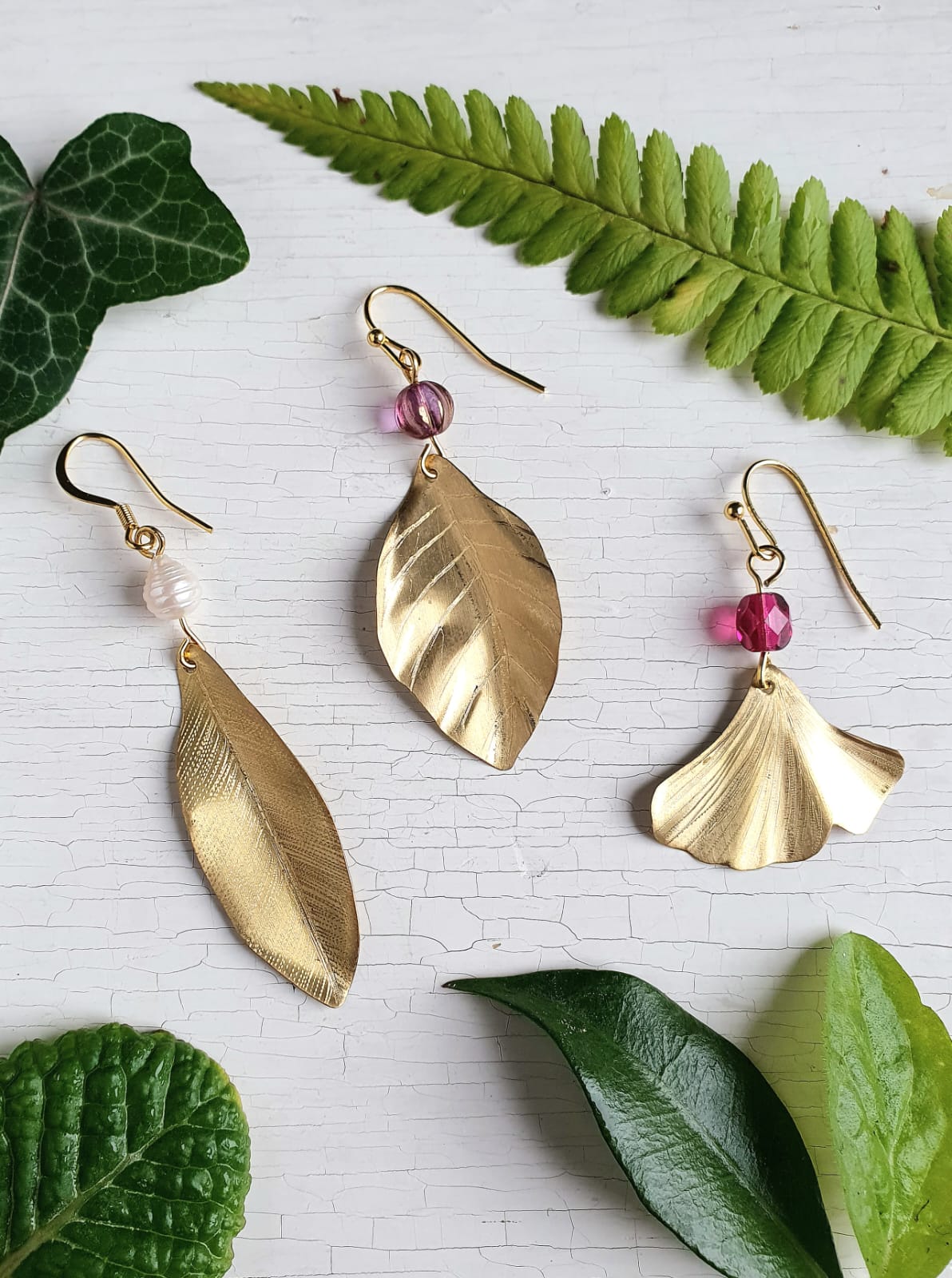 Realizza un paio di orecchini in ottone a forma di foglia e abbina una perla di vetro o perla di fiume barocca.