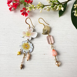 Orecchini spaiati con fiori.